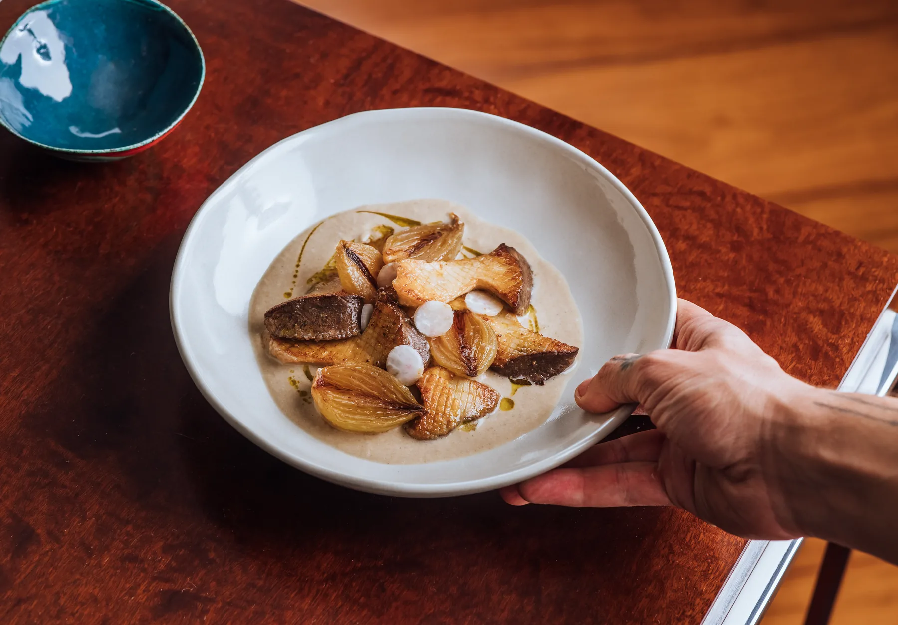 Cogumelos salteados com velouté de peixe, cebola caramelizada e rabanete